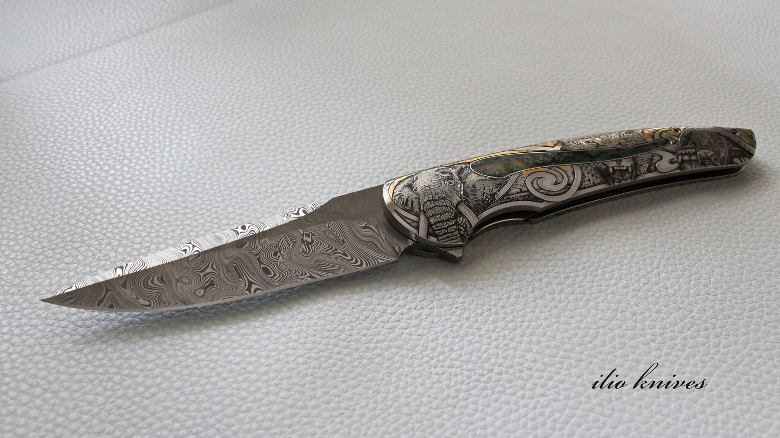 Open Big Five flipper with Damasteel blade and wildlife bulino engraving